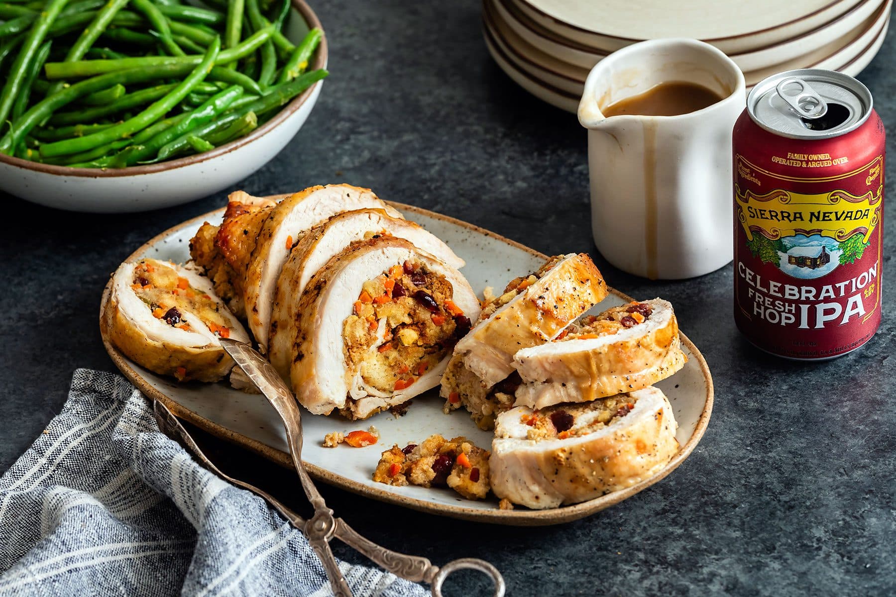 A plate with slices of stuffed turkey breast next to a can of Sierra Nevada Celebration IPA