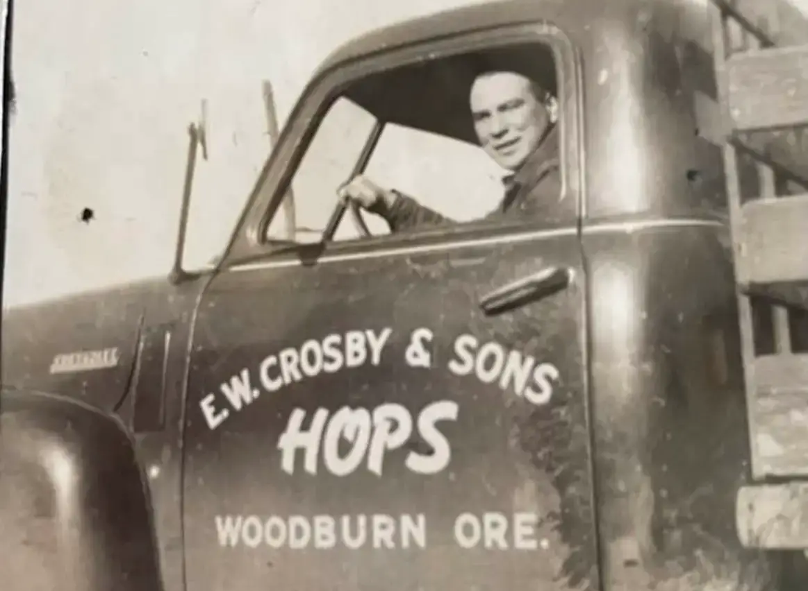Person looks out the window from an old work truck in this vintage photo